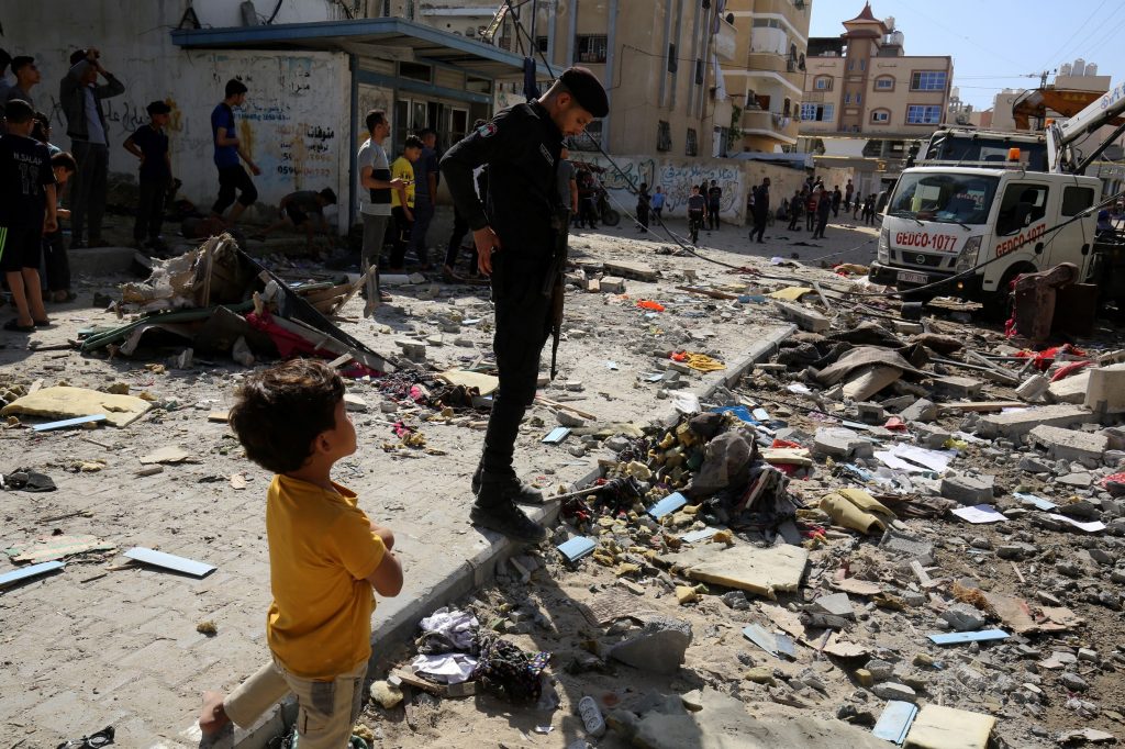 Palestinians inspect damage from Israeli air strike in Khan Yunis in Gaza, May 2021
