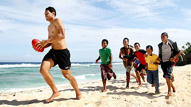 Rugby league professional Israel Folau, playing footy with kids on the beach, is he a good  role model ???