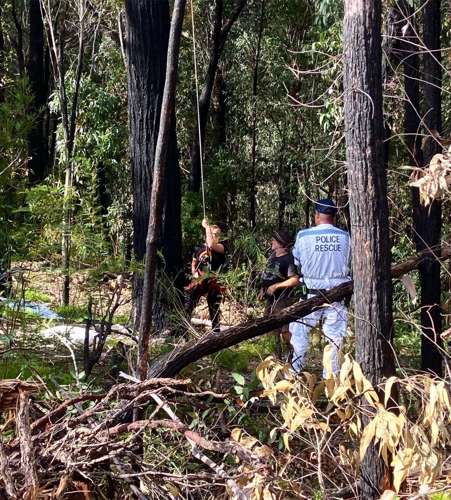 Takesa Frank coming down from tree sit at Shallow Crossing where she protested native forest logging, two police officers waiting for her on the ground